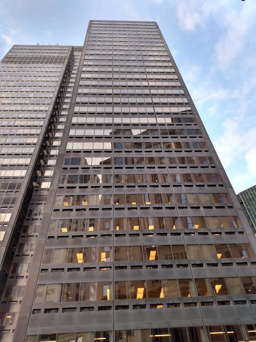 Skyscrapers in a financial district, with a company logo on a white plate